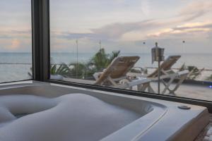 a bath tub with a view of the ocean at Sensira Resort & Spa Riviera Maya All Inclusive in Puerto Morelos