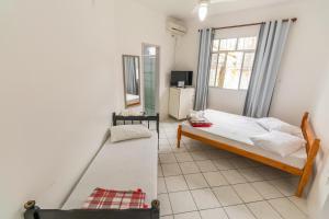 ein kleines Schlafzimmer mit einem Bett und einem Fenster in der Unterkunft Pousada Santa Ana in Florianópolis