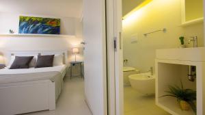 a white bedroom with a bed and a bathroom at Stesicoro Exclusive House in Catania +229 photos