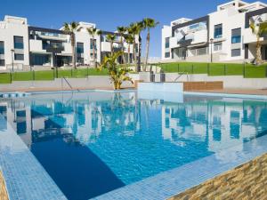 ein Pool vor einigen Apartmentgebäuden in der Unterkunft Oasis Beach 8 Top floor apartment in Torrevieja Punta Prima in Torrevieja