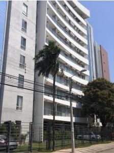 ein hohes Gebäude mit einer Palme davor in der Unterkunft Departamento Equipetrol Ejecutivo Familiar in Santa Cruz de la Sierra