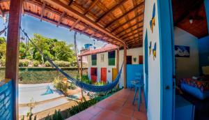 - une terrasse couverte avec un hamac dans une maison dans l'établissement Pousada Aloha Arraial, à Arraial d'Ajuda