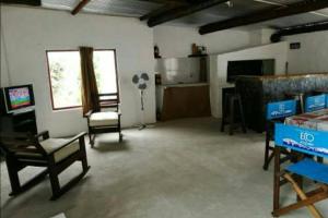 匹里亞波里斯的住宿－Casa ideal para descansar Piriápolis，客厅配有电视和桌椅