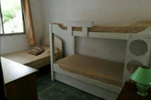 1 Schlafzimmer mit 2 Etagenbetten und einem Fenster in der Unterkunft Casa ideal para descansar Piriápolis in Piriápolis