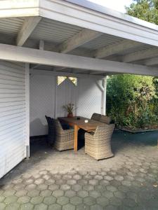 patio con tavolo e sedie sotto un tetto di Pension im Heidort a Oyten