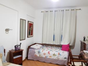 um pequeno quarto com uma cama e uma janela em Hotel Cavalinho Branco Flat Service 615 em Águas de Lindoia