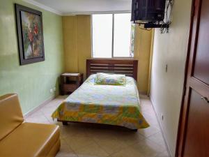 Habitación pequeña con cama y ventana en Bueno, Bonito, Barato y cerca a El Poblado, en Medellín