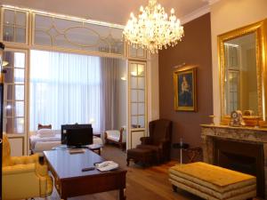 a living room with a fireplace and a chandelier at Best Western Plus Park Hotel Brussels in Brussels