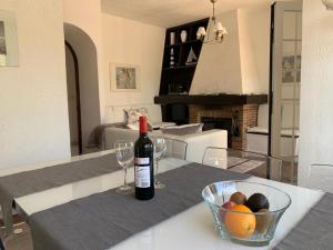 a bottle of wine and a bowl of fruit on a table at Annette in Albir