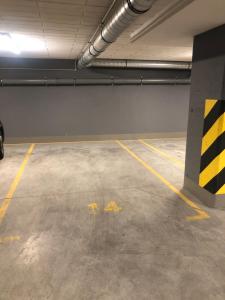 un garage vide portant des inscriptions jaunes au sol dans l'établissement Natural Hel Apartamenty, à Hel