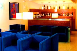 a waiting room with blue chairs and a bar at Hotel Paulo VI in Rio Maior