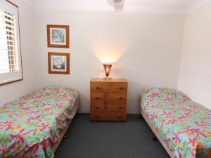 - une chambre avec deux lits et une commode avec une lampe dans l'établissement Casa Pacifica Villa 4, à Forster