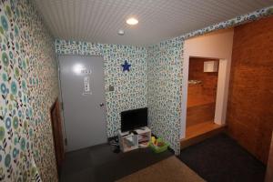 un pasillo con una habitación con papel pintado azul y verde en Alpine Villa Nozawa, en Nozawa Onsen
