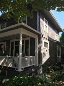 um alpendre frontal de uma casa com um corrimão branco em Boutique Style Apartment in the heart of SE em Portland