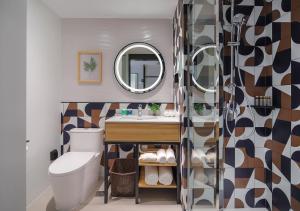 a bathroom with a toilet, sink, mirror and bath tub at Campanile Shanghai Bund Hotel in Shanghai