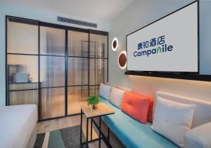 a living room with a couch and a large screen at Campanile Shanghai Bund Hotel in Shanghai