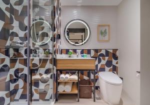 a bathroom with a toilet, sink and mirror at Campanile Shanghai Bund Hotel in Shanghai