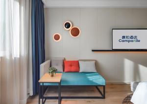 a living room with a blue couch and a table at Campanile Shanghai Bund Hotel in Shanghai