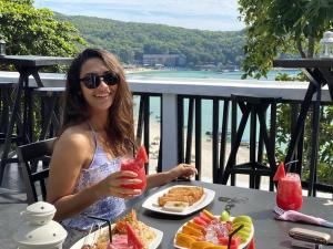 a woman sitting at a table with a plate of food at Aman Dan Laut in Perhentian Island