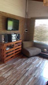 Una sala de estar con un sofá y un televisor de pantalla plana. en Cabaña Las liebres, en San Roque