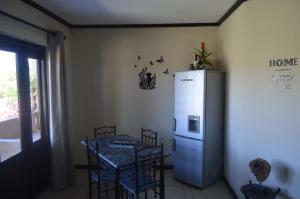 a kitchen with a table with chairs and a refrigerator at Oppidam Self Catering in Clanwilliam