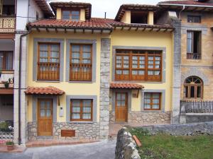 uma casa amarela com portas e janelas de madeira em Casa Rural La Indiana I y II em Porrúa