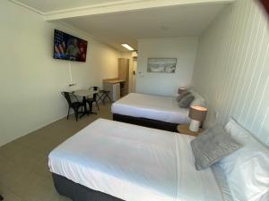 a hotel room with two beds and a table at Kingston Lobster Motel in Kingston South East