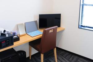 a desk with a laptop and a desktop computer at Zeus House in Nishinoomote