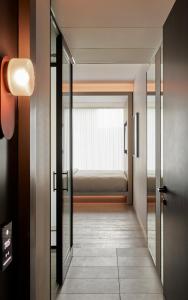 - un couloir avec un lit dans une chambre dans l'établissement Little National Hotel Sydney, à Sydney