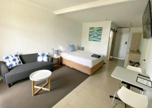 Cette chambre comprend un lit, un canapé et une table. dans l'établissement Kingston Lobster Motel, à Kingston South East