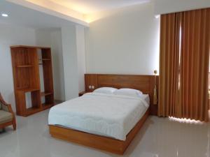 a bedroom with a large bed with a wooden headboard at Diva Residence in Yogyakarta