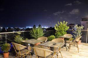 a patio with tables and chairs on a roof at night at Hotel Grand Mark in Istanbul