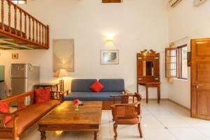 班加羅爾的住宿－卡薩小屋酒店，客厅配有沙发和桌子