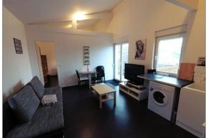 - un salon avec un canapé et une télévision dans l'établissement Appartement complet, à Stiring-Wendel