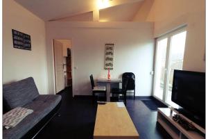 - un salon avec un canapé et une table dans l'établissement Appartement complet, à Stiring-Wendel
