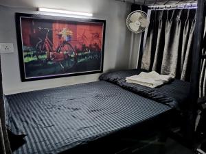 1 cama en una habitación con una foto de una bicicleta en la pared en Dormitory, en Udaipur
