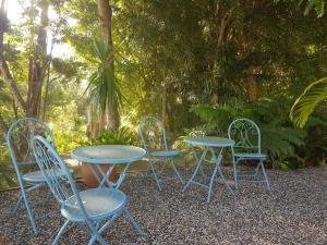 un grupo de mesas y sillas sentados en una mesa en Mapleton Peaceful Provence BnB, en Mapleton
