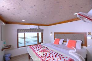 a bedroom with a large bed with red pillows at Soma House Boat in Alleppey