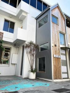 uma casa branca com uma porta de madeira em 中目黑包棟旅宿Nakameguro em Tainan