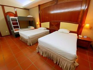 ein Schlafzimmer mit zwei Betten und einem Etagenbett in der Unterkunft Ponderosa Golf & Country Resort in Johor Bahru + 43 Fotos