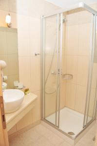 a bathroom with a shower and a white sink at Kleopatra Villas - Seaside Suites in Kolios