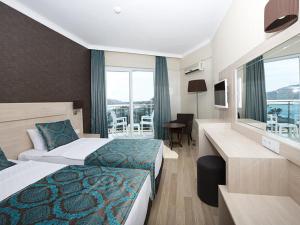 een hotelkamer met 2 bedden en een balkon bij Parador Beach Hotel in Alanya