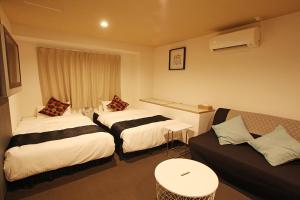 a hotel room with two beds and a couch at Hotel Pagoda in Nara