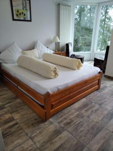 a large bed with white sheets and pillows on it at Vila Liliacul in Stana de Vale