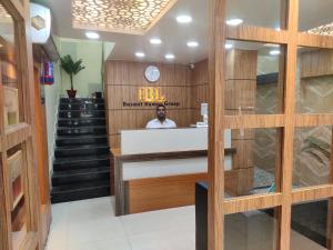 a man sitting at a counter in a room with stairs at HOTEL CENTRAL SQUARE "A Couple Friendly Hotel" in Muzaffarpur