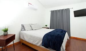 1 dormitorio con 1 cama y ventana con TV en Casa Antara en Ciudad Juárez