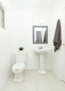 a white bathroom with a toilet and a sink at Casa Antara in Ciudad Juárez
