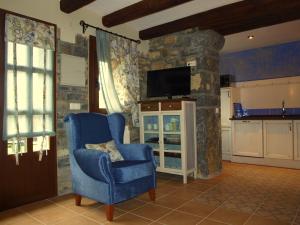 a living room with a blue chair and a tv at Apartamentos Casa Gallan in Sarvisé