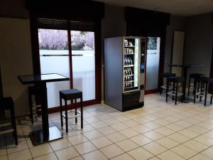 a bar with stools and a refrigerator with wine bottles at Le Médicis in Roussillon en Isere