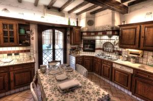 uma grande cozinha com armários de madeira e uma mesa em B&B Le Noci di Feo em Módena